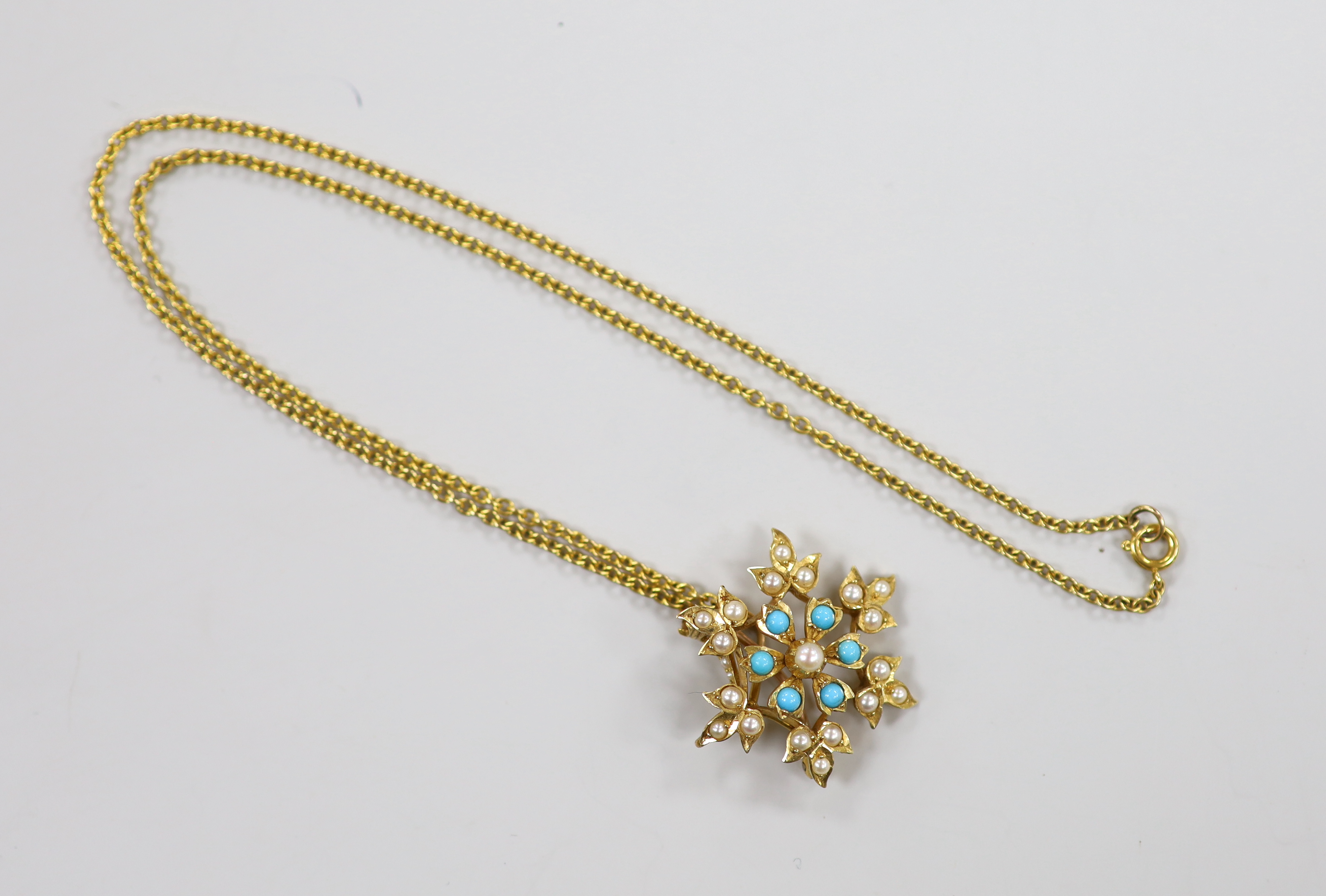 An Edwardian yellow metal, turquoise and seed pearl set flower head pendant brooch, overall 36mm, on a 9ct chain, gross weight 7.4 grams.